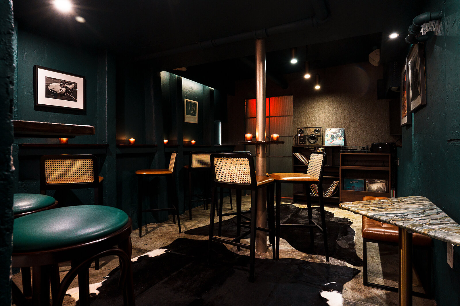 The Listening Room — dark green walls, cane-back stools, vinyl shelves