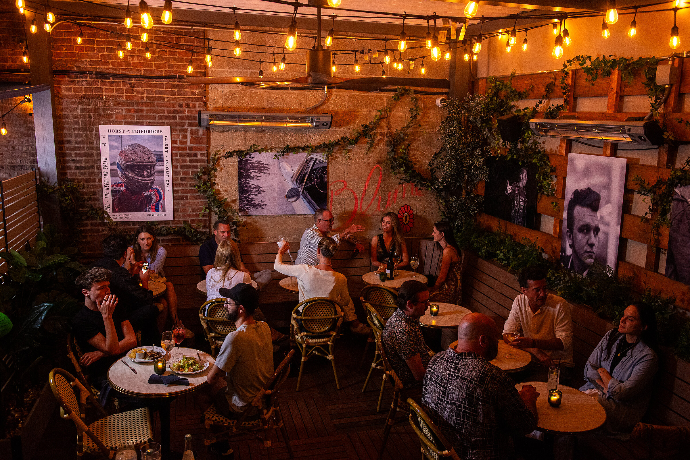 Guests dining on Jeremy's back patio at night, under warm string lights
